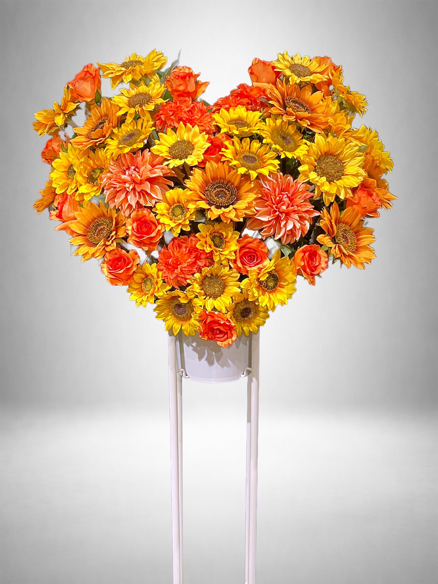 ひまわりとオレンジのバラでハート型にまとめたRe:Bloomシリーズのスタイル装花