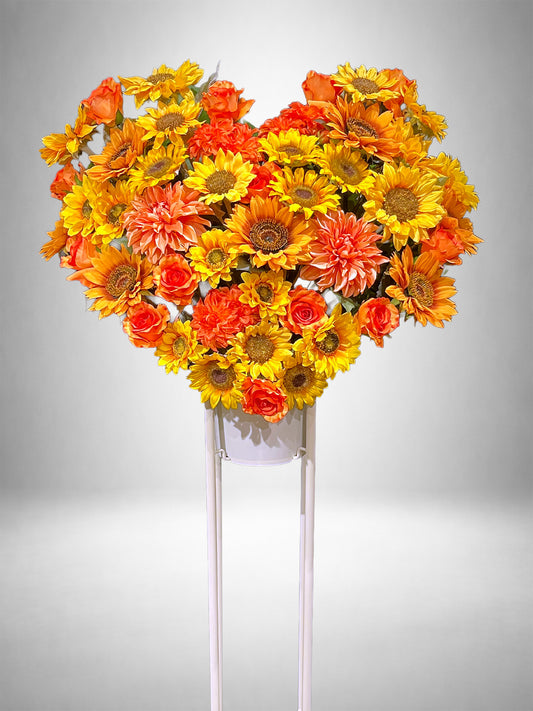 ひまわりとオレンジのバラでハート型にまとめたRe:Bloomシリーズのスタイル装花