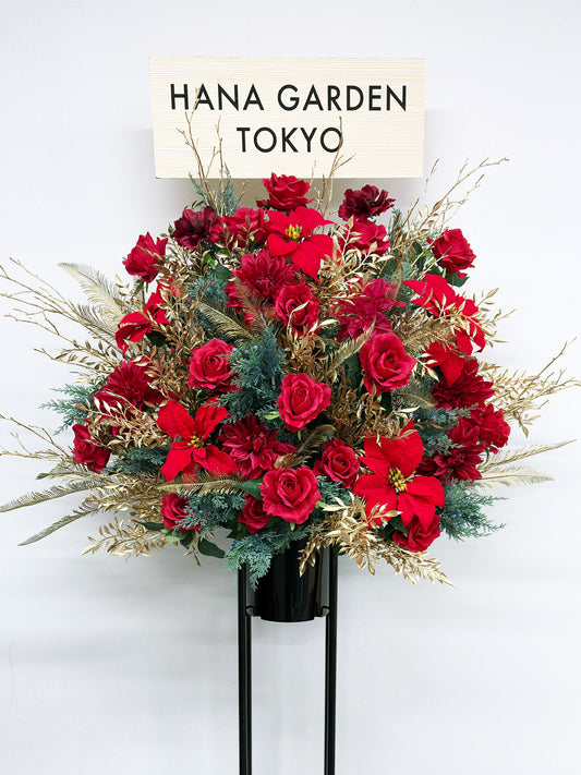 ルビーレッドの花々とゴールドリーフが輝く華やかなスタンド花。
高級感のあるアーティフィシャルフラワーデザインで、ライブやイベント装花におすすめ。