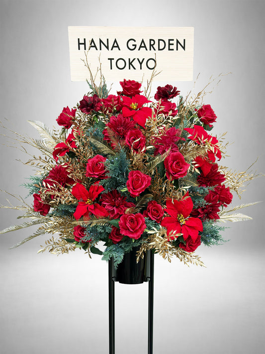 ルビーレッドの花々とゴールドリーフが輝く華やかなスタンド花。
高級感のあるアーティフィシャルフラワーデザインで、ライブやイベント装花におすすめ。