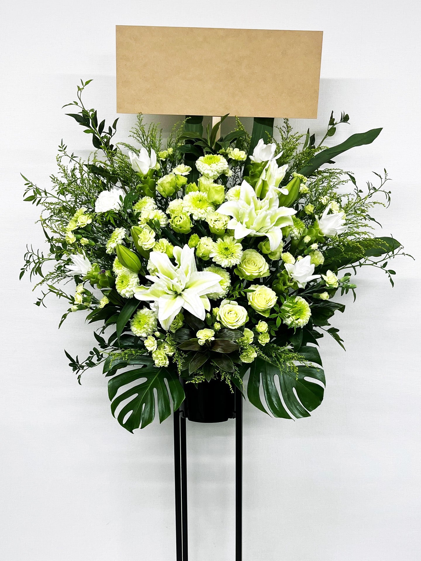 白と淡いグリーンの花々が織りなす清楚で上品なスタンド花。
ユリやローズを中心にした柔らかく明るい生花デザイン。
