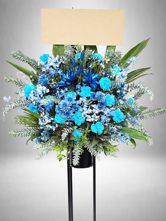 スカイブルーとアクアトーンが爽やかに映えるスタンド花。
ブルーグラデーションが美しい生花デザインで、ライブ・イベント装飾にもおすすめ。