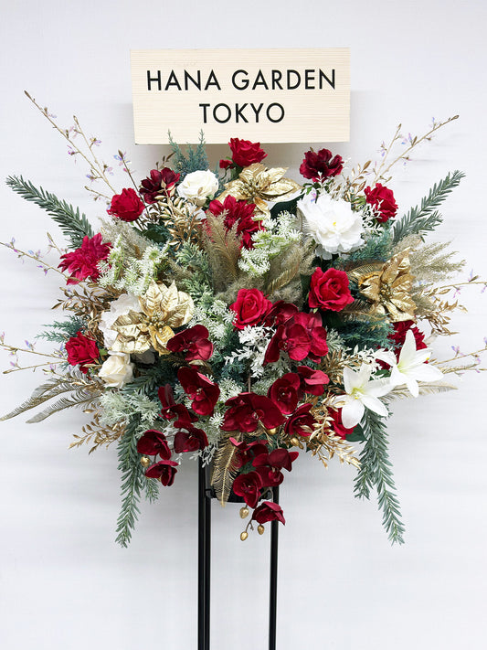 深紅とホワイト、ゴールドが調和したクラシカルで上品なスタンド花。
アーティフィシャルフラワーを使用した華やかな祝花で、公演祝い・周年祝いに最適。