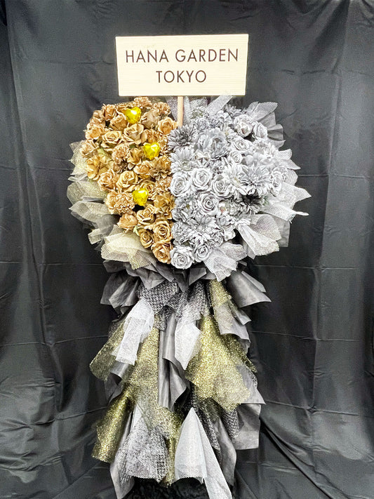 ゴールドとシルバーの2つのハートが輝くアーティフィシャルフラワースタンド。
メタリックな質感と立体感が美しく、公演祝い・周年祝い・イベント装花に最適。