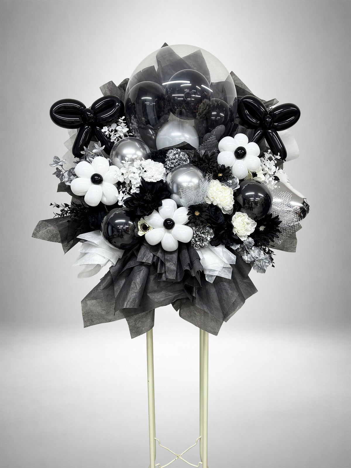 ブラック・ホワイト・シルバーの花とバルーンを組み合わせたフラワースタンド。黒担当の推し活やライブ・公演祝い、生誕祭、誕生日、周年祝いにおすすめのモノトーンフラスタです。