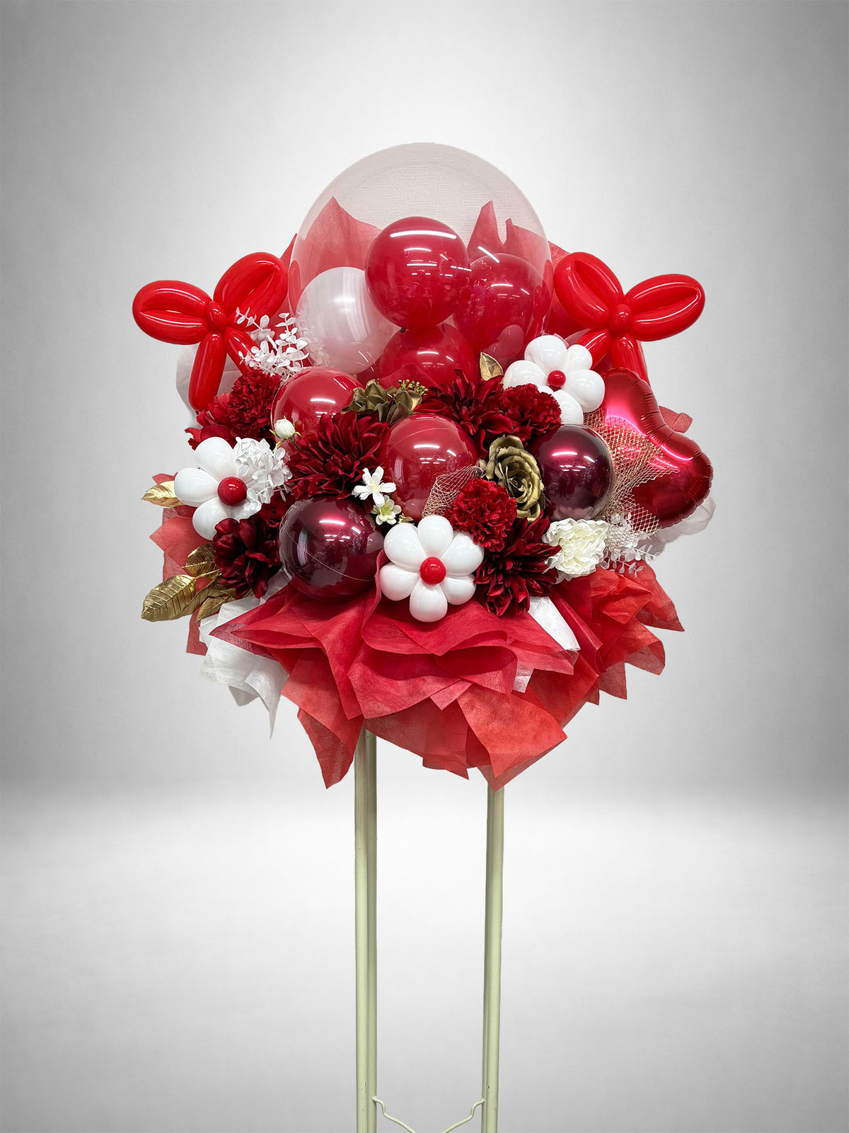 レッド・ゴールド・ホワイトの花とバルーンを組み合わせた華やかなフラワースタンド。赤担当の推し活やライブ・公演祝い、生誕祭、誕生日、周年祝いにおすすめのバルーンフラスタです。
