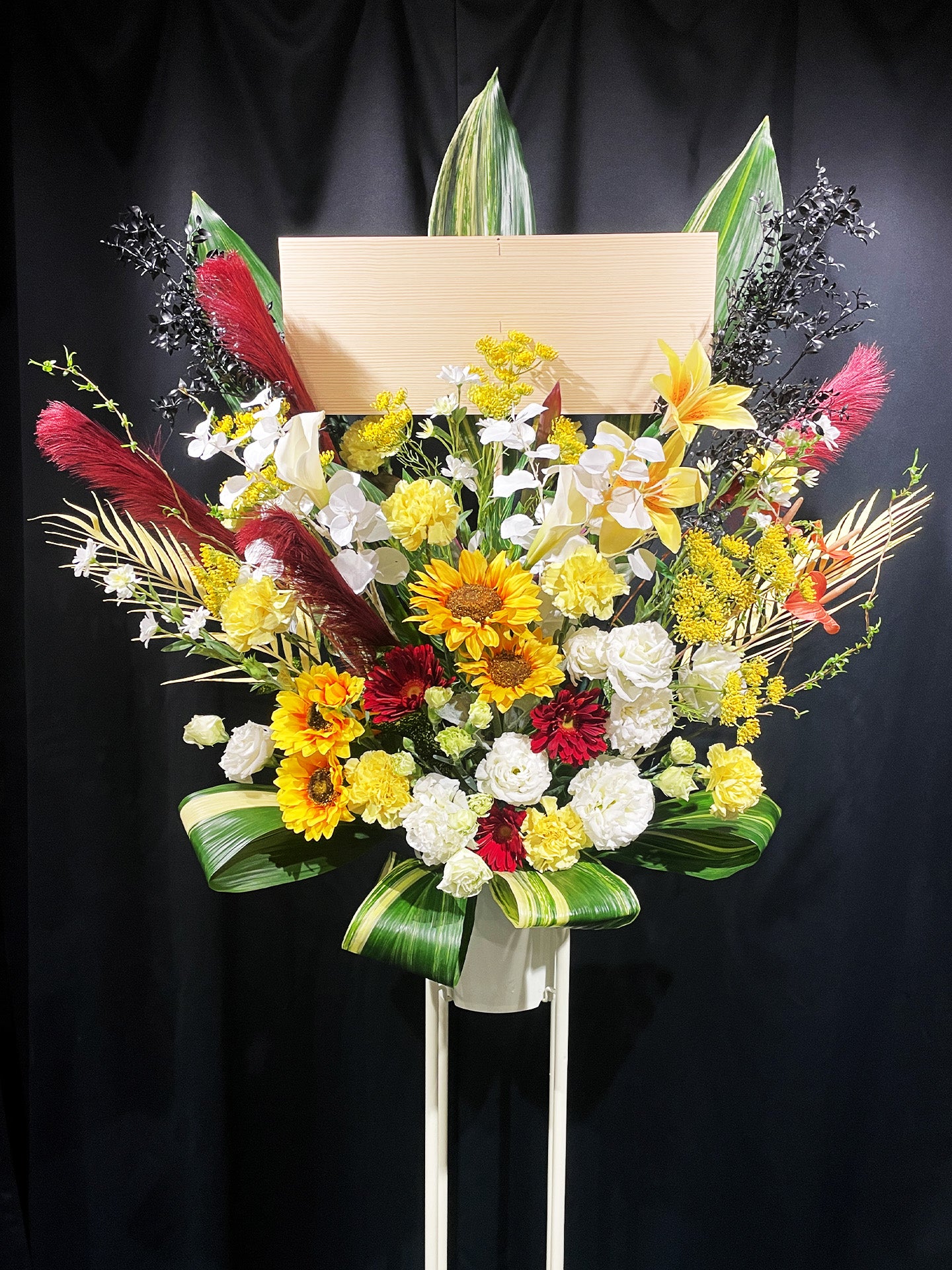 サンフラワーと赤のアクセントが映えるアーティフィシャルスタンド花（夏の公演祝いやイベントに贈る華やかな祝い花）｜Re:Bloom HANA GARDEN TOKYO REX FLOWER