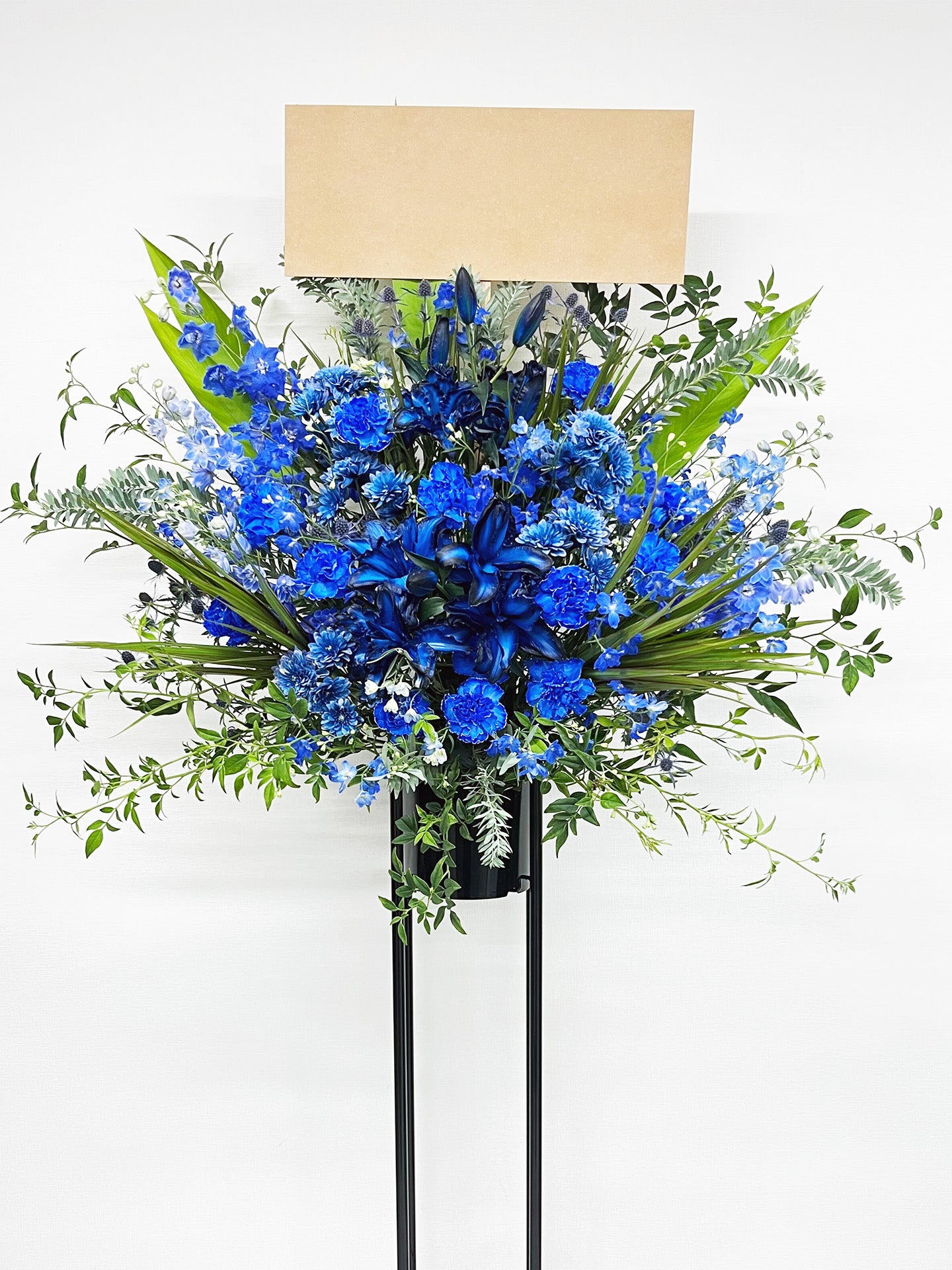 深いブルーとグリーンのコントラストが印象的なスタンド花。
リリーやカーネーションを使用した上品でスタイリッシュな生花デザイン。